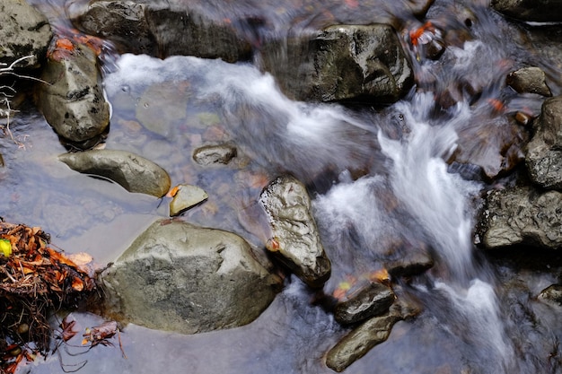 Stream flowing through rocky path in mountains