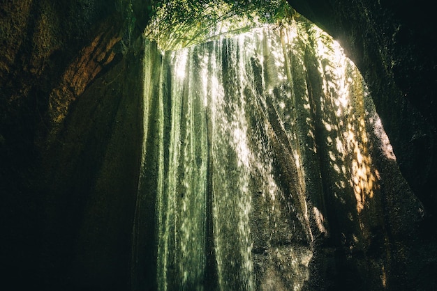 写真 インドネシアのバリ州の洞窟を流れるtucadcepung滝の流れ