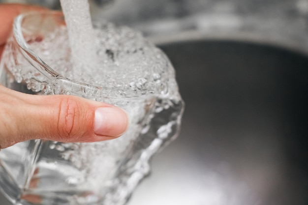 Photo a stream of water flows into a glass cup