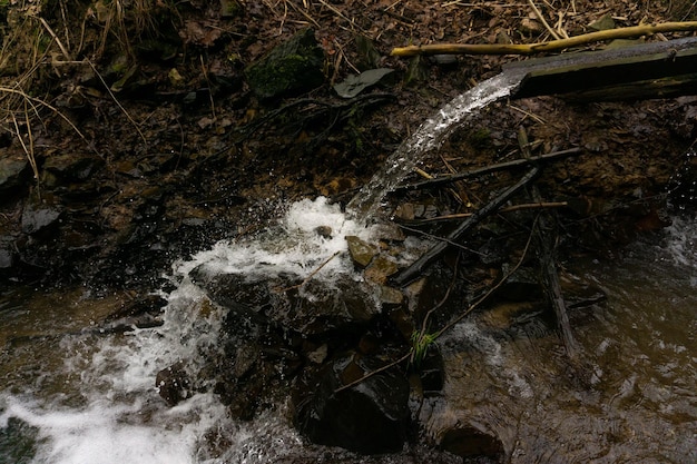 Photo a stream of water is pouring out of a rock.