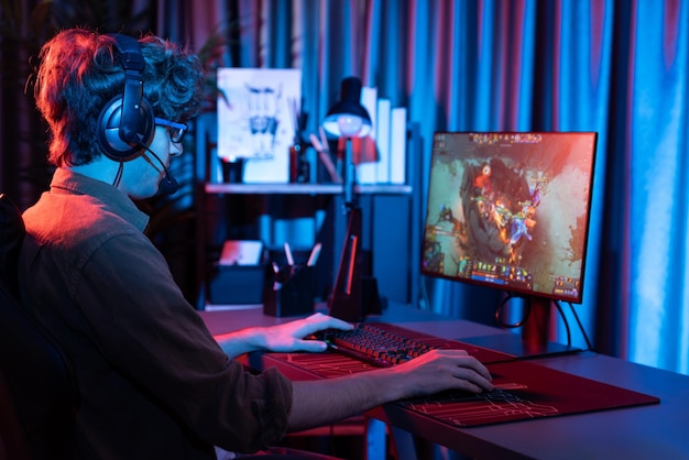 streamer playing fighting moba wearing headphone and mic at back side gusher