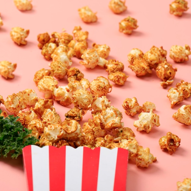 Foto streepdoos met popcorn op roze achtergrond