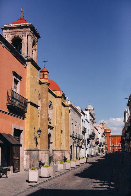 Street amidst buildings against blue sky