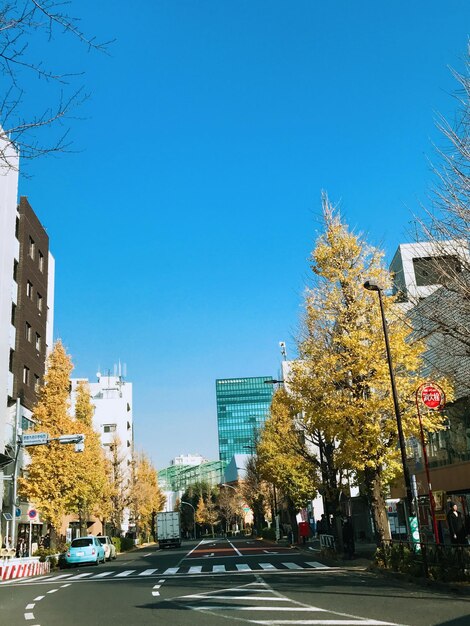 Street amidst buildings against clear blue sky