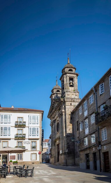 Street amidst buildings against clear blue sky