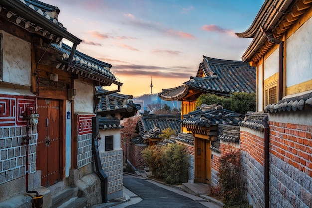 street amidst buildings in city against sky during sunset