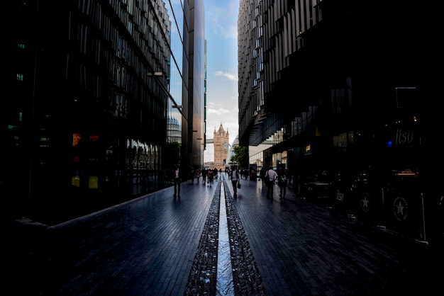 Photo street amidst buildings leading towards tower bridge