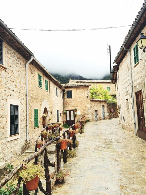 Foto strada in mezzo alle case in città contro un cielo limpido