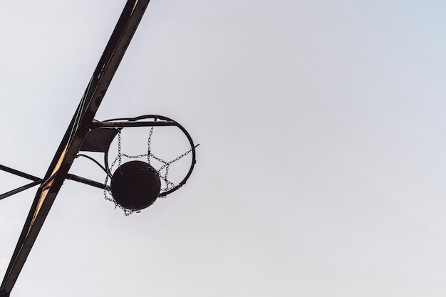 Street basketball ball falling into the hoop Side view