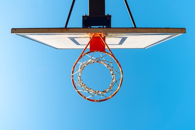 Street basketball hoop on a sunny day with blue sky in the surface.