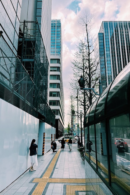 Street by modern buildings in city against sky