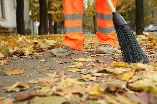 秋の日に屋外で落ち葉を掃除するストリート クリーナー