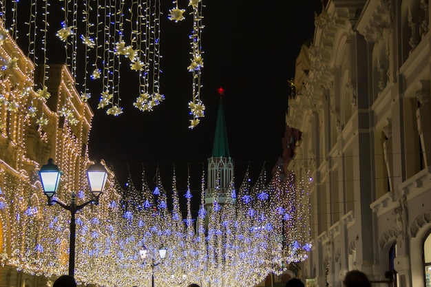 クリスマスと新年のお祝いの装飾的な電球のために飾られた通り