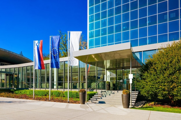 Street at Entrance into Medical center building at Old city in Rogaska Slatina in Slovenia in South Styria. Travel in Europe Slovenian luxury spa resort. Modern glass architecture exterior with flags.