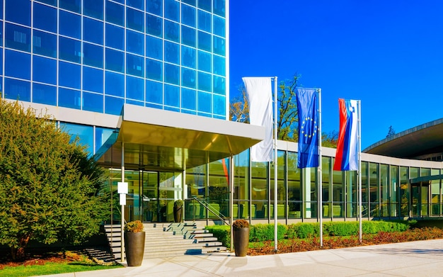 Street at Entrance into Medical center building at Old city in Rogaska Slatina in Slovenia in Styria. Travel in Europe Slovenian spa resort. Modern glass architecture exterior with flags.