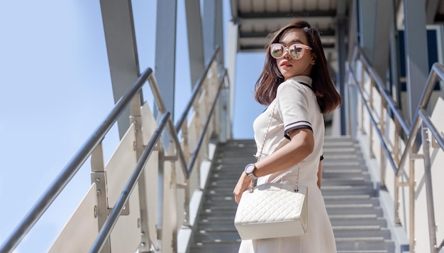 스카이트레인 역으로 가는 공공 계단에서 아시아 비즈니스 여성의 스트리트 패션