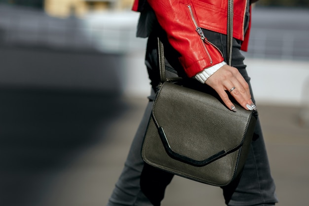 Street fashion concept. Woman in stylish apparel holding black leather purse. Space for text