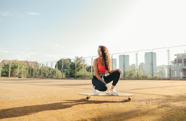 Street fashion meisje skater poseren op longboard