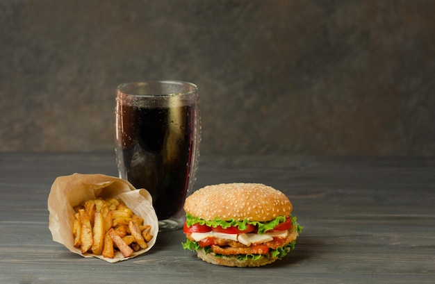 Street food or fast food Hamburger french fries and cola on table with wooden background Unhealthy burger with beef