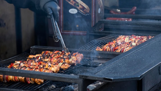 ヨーロッパのウィンター フェアで焼かれる串焼きバーベキューの屋台の食べ物