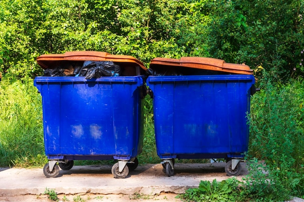 Street garbage cans overflowing garbage from large garbage cans\
on wheels for garbage recycling