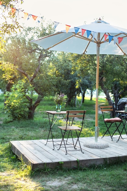 우산과 나무 의자, 테이블이 있는 거리 인테리어 야외 카페 레스토랑