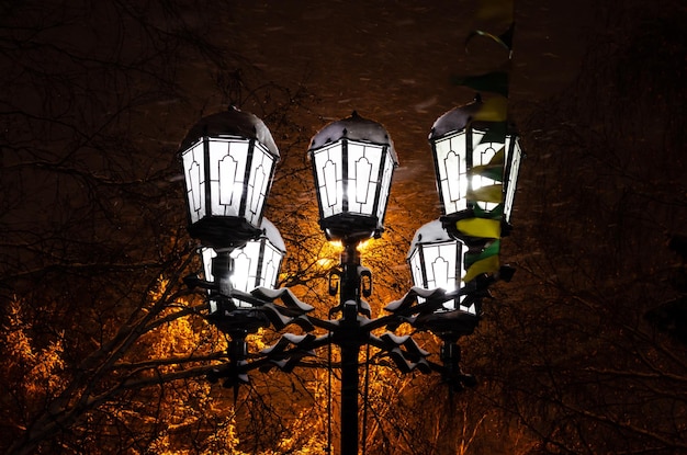 A street lamp in the dark with the lights on.