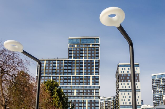 A street lamp in front of a building with a blue sky in the background.