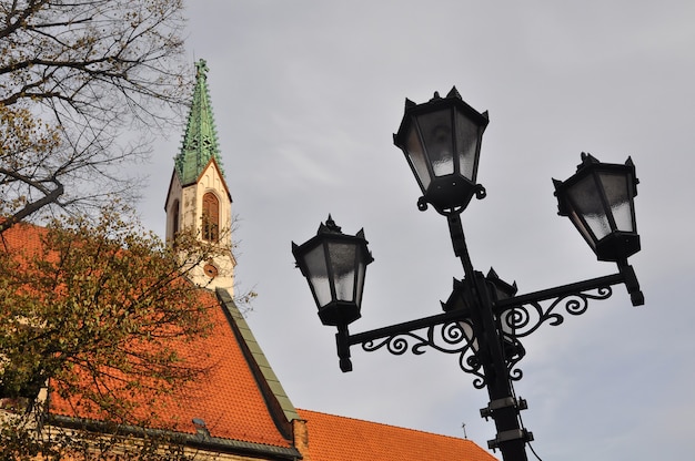Уличный фонарный столб с четырьмя старинными готическими фонарями в старой риге