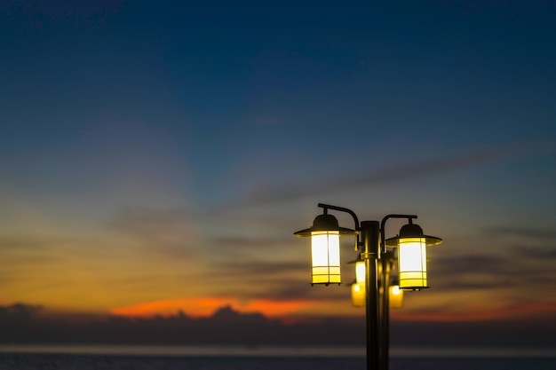 Photo street lamps at night. a brightly lit street lamps at sunset.