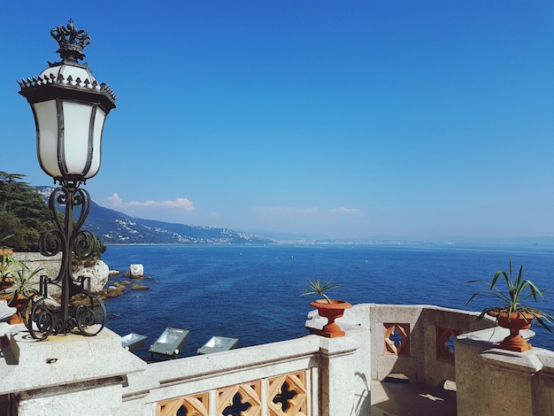 Foto luce di strada sul mare contro un cielo blu limpido