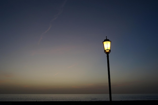 Фото Уличный фонарь на море на фоне неба на закате