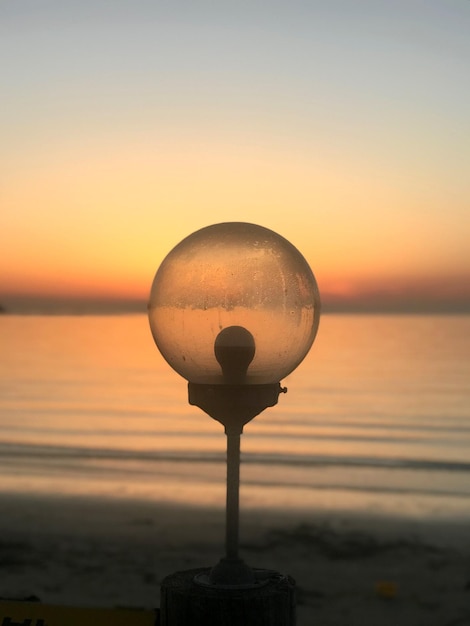 Foto luce di strada dal mare contro il cielo durante il tramonto