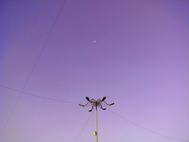 Street light and power lines against sky