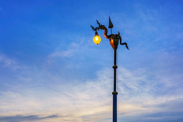 Street light or street lamp of Naga statue with white clouds and blue sky in evening , Nong Khai , Thailand