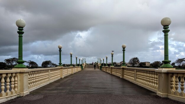 Street lights on bridge against sky