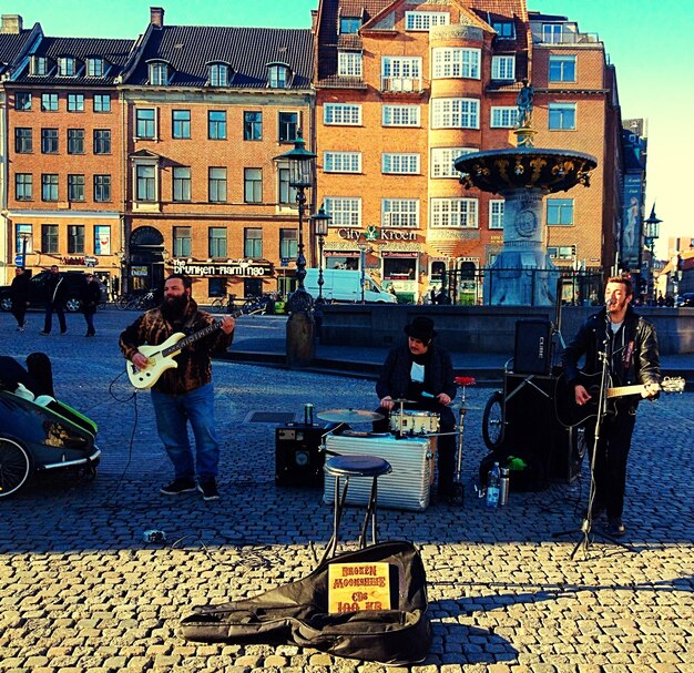 Street musicians on cobblestone against buildings