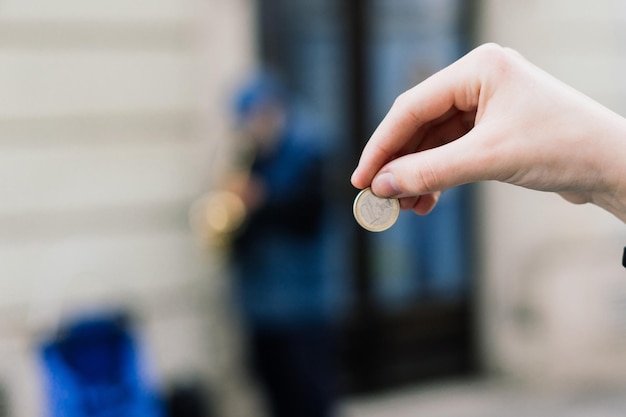 Photo street old performer musician plays saxofon blurred coin in hand focused