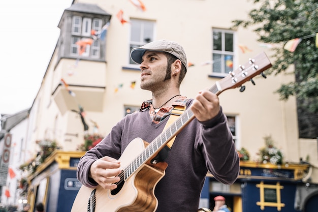 Photo street performer man playing the guitar