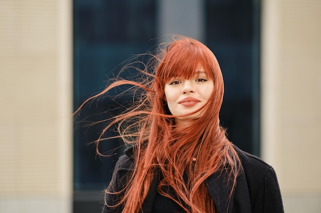 Street portrait of a happy young redhaired woman