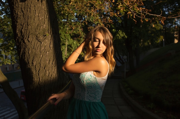 Street portrait of young attractive model with wavy hair posing at sunny day