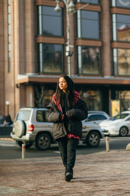 目をそらしている街の通りでファッショナブルな特大の服を着た女性のストリートルポルタージュ写真