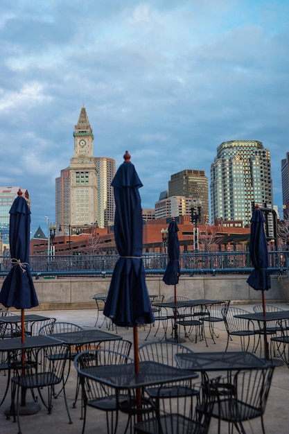 Street restaurant with umbrellas and Custom House Tower with Financial district skyline in downtown Boston, Massachusetts, the United States.