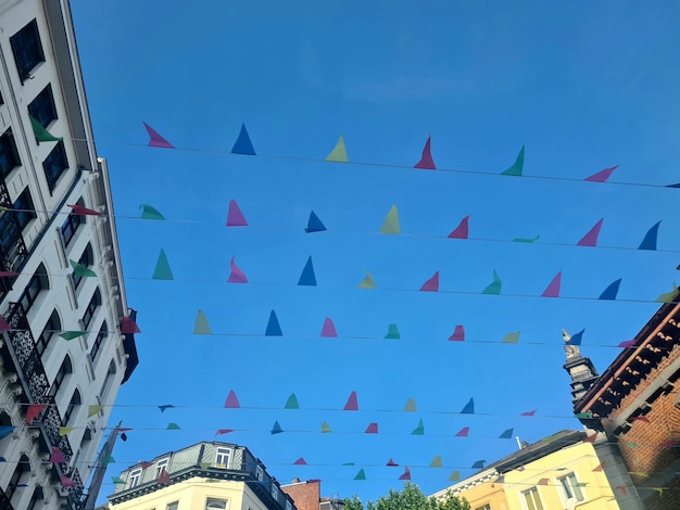 A street scene with a blue sky and colorful flags in the background.