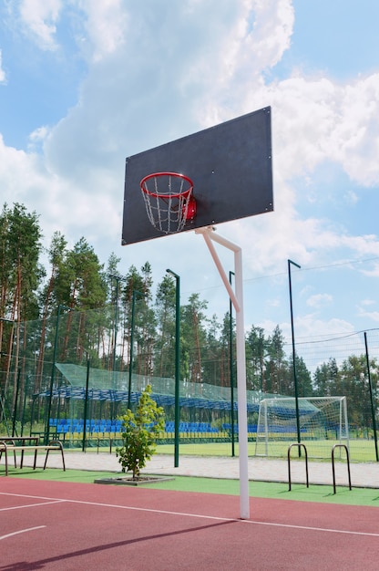 Street sport concept. basketball backboard with a basket made\
of iron chains on a sunny day. vertical view. low angle view