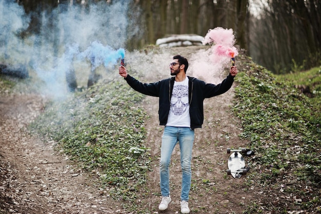 Street style arab man in eyeglasses hold hand flare with red and blue smoke grenade bomb