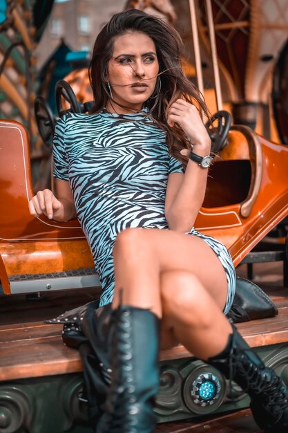 Street style portrait of a young brunette on a carousel