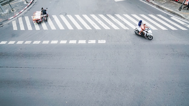 street on the top view with the crosswalk sign on the road and car and motorcycle 