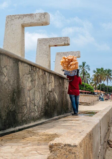 Photo street vendor on the beach street vendor walking and selling various types of food on the beach