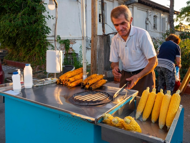 Уличный торговец кукурузой на улице курорта в Греции.